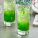 Two glasses of green drinks with ice and Fanale Honeydew Fruit Jam smoothie paste.
