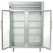 A Traulsen two section glass door reach-in refrigerator with shelves inside.