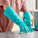 A person wearing Lavex green nitrile gloves cleaning a counter.