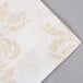 A white napkin with a gold pattern on it.
