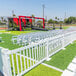 Mod-Traditional white fence with white chairs on grass.