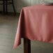 A table with a mauve Intedge rectangular tablecloth.