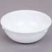 A white Thunder Group Nustone melamine nappie bowl on a gray surface.
