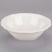 A CAC ivory scalloped edge bowl on a gray surface.