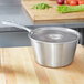 A silver Vollrath stainless steel pot with a lid on a counter.