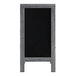 A wooden A-frame chalkboard with a black board on it in a wooden frame.