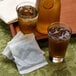 A tray with two glasses of brown Bigelow iced tea with ice.