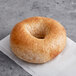 An Original Bagel New York Style Honey Wheat bagel on a white surface.