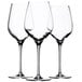 Three Stolzle Exquisit Royal white wine glasses on a white background.