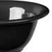 A close-up of a Carlisle black melamine nappie bowl with a white rim.