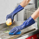 A person wearing blue Showa Nitrile gloves cleaning a surface.