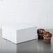 A white box with two cupcakes on top.