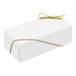 A white candy box with gold ribbon.