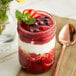 A glass jar of Oregon Fruit Mixed Berry Filling with a yogurt topping.