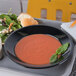 A tray with a Carlisle black polycarbonate soup bowl of soup and a side of salad.