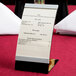 A Tablecraft curved menu displayette with a menu card on a stand.