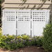A white Suncast lattice panel fence in a garden.