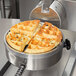 A Nemco commercial waffle maker with cooked waffles in it.