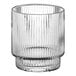 A clear glass votive holder with a ribbed cylindrical base.