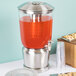 A Tablecraft stainless steel and plastic beverage dispenser filled with a red liquid.