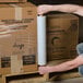 A person holding a roll of 20" x 1000' Pallet Wrap Film