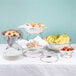 A table with a variety of food on display using American Metalcraft stainless steel risers.