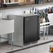 A black Perlick undercounter refrigerator with a bar on top.