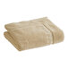 A folded beige 1888 Mills Magnificence Pima cotton bath mat.