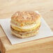A Grand Prairie Spicy Sausage, Egg, and Cheese Jalapeno Biscuit Sandwich on a white plate.