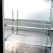 A metal shelf with metal rods in a Beverage-Air back bar refrigerator.