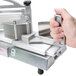 A hand holding a Nemco 3/16" tomato slicer pusher over a machine.