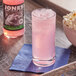 A glass of Jones Watermelon Soda with ice next to a bowl of popcorn.
