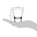 A hand holding a Libbey Endeavor shot glass with measurements.