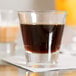 A Libbey shot glass filled with brown liquid.
