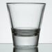 A close up of a clear Libbey shot glass with a half empty rim.