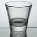 A Libbey clear shot glass on a reflective surface.