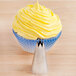 A cupcake with yellow frosting on top piped with an Ateco Open Star Piping Tip.