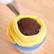 A cupcake with yellow icing piped on using an Ateco open star piping tip.
