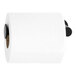 A roll of toilet paper on a black and metal Bobrick toilet paper holder.