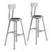 Two gray steel lab stools with black seat and backrest.