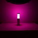 An Ape Labs Cream LED table light shining on a purple table.