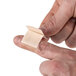 A person putting a Medique adhesive bandage strip on a finger.