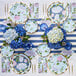 A table set with Sophistiplate Hydrangeas paper plates and napkins on a table outdoors.