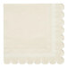 A white napkin with scalloped edges.