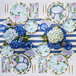 A table set with Sophistiplate Hydrangeas paper guest towels, blue and white plates, and flowers.