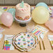 A table set with Sophistiplate birthday lunch napkins, plates, and balloons with a cake on it.