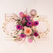 A table setting with pink and purple flowers and Sophistiplate Bella Gold plastic cutlery.