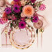 Sophistiplate Bella Gold plastic cutlery on a table with pink and gold plates and flowers.