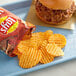 A blue tray with a burger and Lay's Wavy Hickory Barbecue Potato Chips.