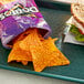 A table with a tray of a sandwich and a bag of Doritos Spicy Sweet Chili Flavored Tortilla Chips.